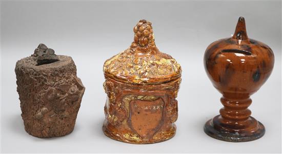 An earthenware money box, a tobacco jar with lid and a Sussex pottery money box